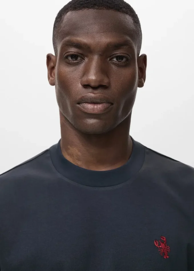 Koszulka wykonana w 100% z bawełny z haftowanym detalem Koszulka wykonana w 100% z bawełny z haftowanym detalem