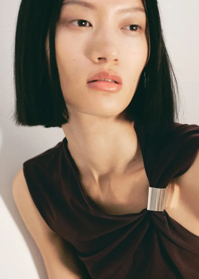 Top z asymetrycznym dekoltem i metalicznymi detalami Top z asymetrycznym dekoltem i metalicznymi detalami